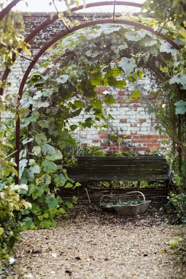 exemple amenagement jardin cure arche en métal pour faire grimper des plantes banc mur en brique 