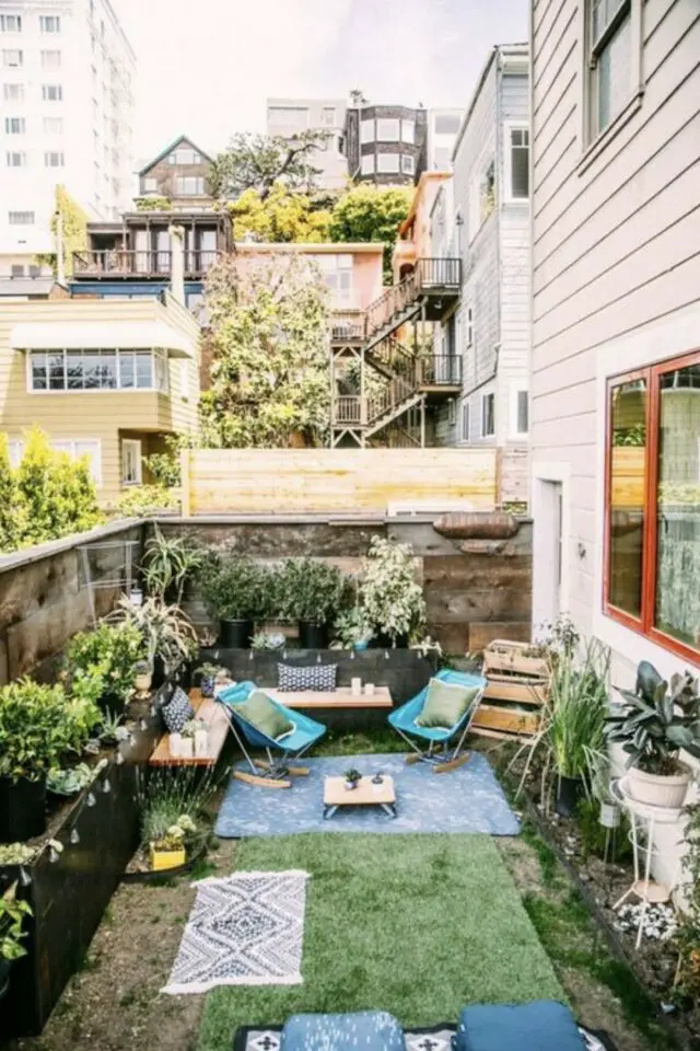 amenagement terrasse appartement ville clôture en bois vieili fausse pelouse plantes extérieures en pot fauteuil à bascule 