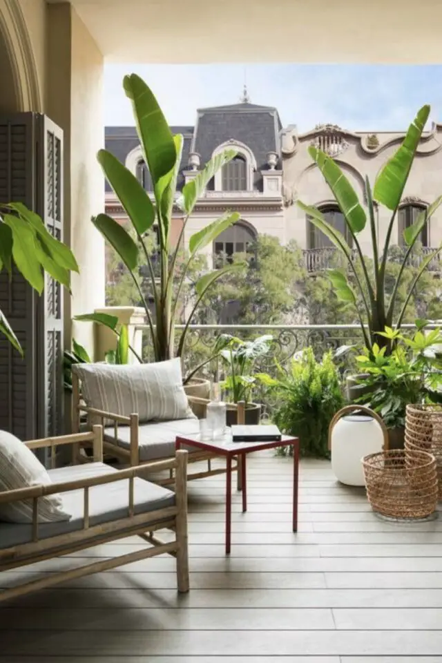 amenagement terrasse appartement ville couverte en bois chic bananier en pot fauteuil en bois coussins cosy paniers en fibres naturelles tressées 