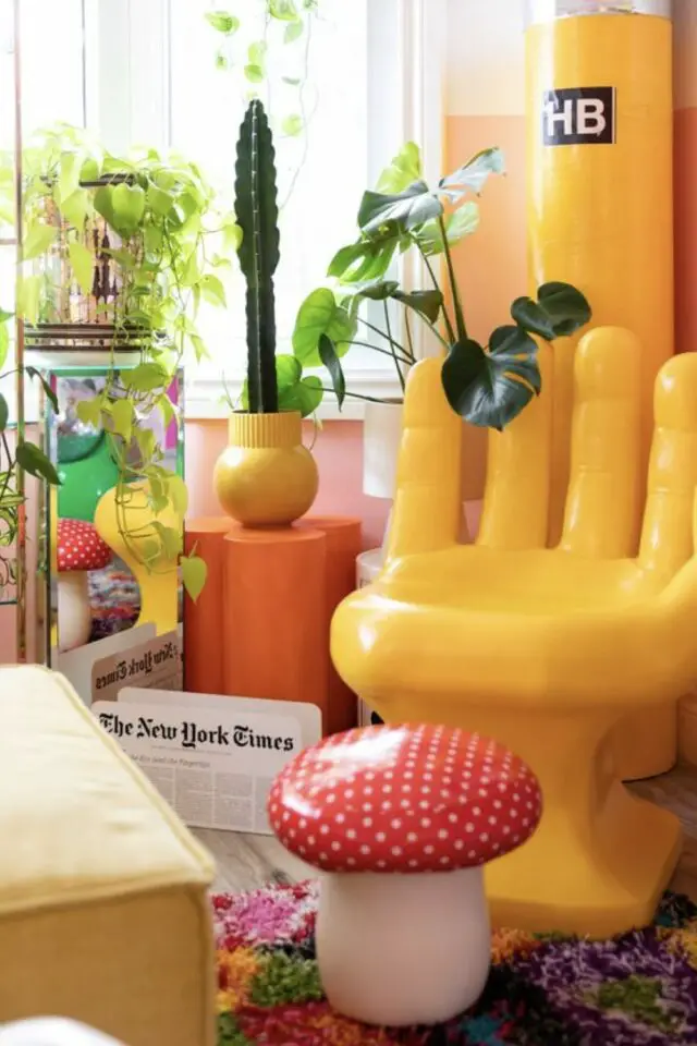 caracteristique decoration maximaliste design fauteuil main jaune bout de canapé orange plantes vertes tropicales cactus repose-pied champignon accumulation 