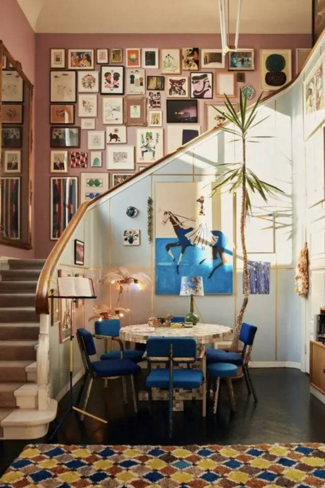 caractéristique décoration maximaliste coin salle à manger tonalités de bleu escalier ouvert mur de cadres galerie peinture rose 