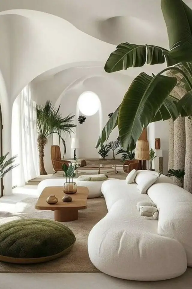 caracteristique decoration zen salon en longueur plafond vouté canapé arrondi table basse en bois pouf coussin de sol vert en velours plante tropicale 