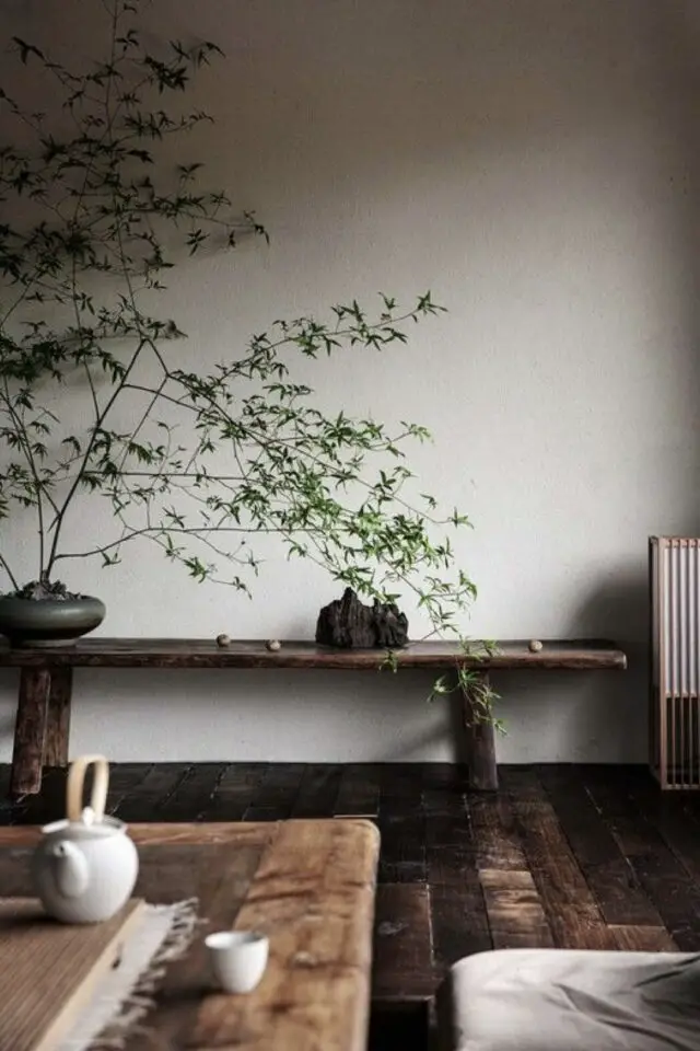 caracteristique decoration zen parquet sombre revêtement de sol banc en bois mur écru wabi-sabi plante verte accessoire thé 