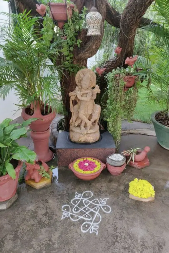 decoration terrasse exterieure voyage  Inde sculpture divinité hindou rangoli plantes vertes et fleurs dans une coupelle en terre cuite 