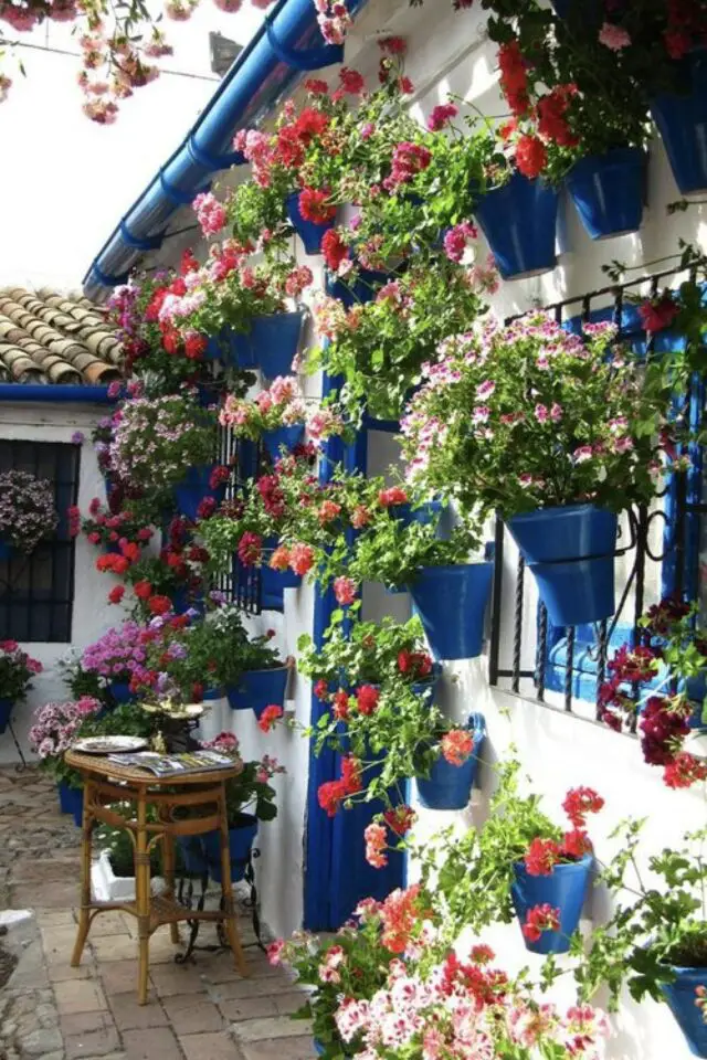 decoration terrasse exterieure voyage  façade maison blanche boiserie peinture bleu pot de fleurs suspendu