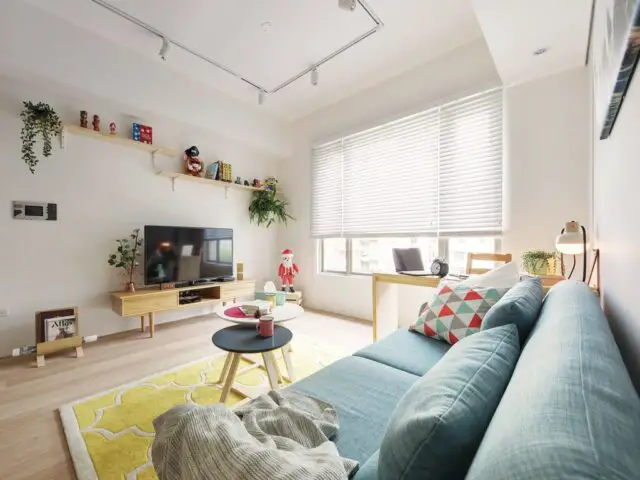 petite maison simple et colorée séjour blanc touche de couleurs canapé bleu tapis jaune meuble en bois clair moderne 