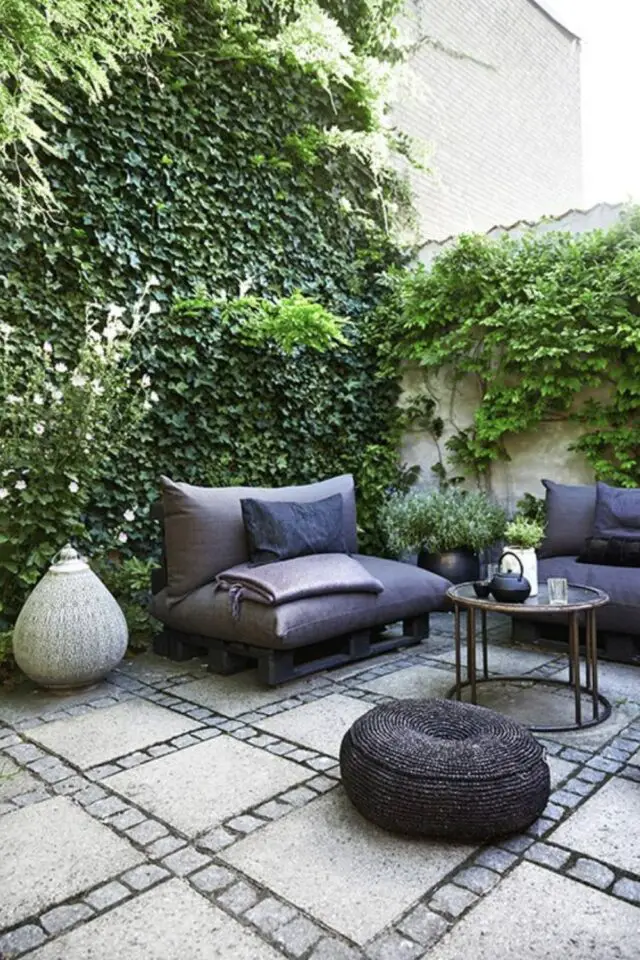 terrasse moderne en béton exemple dalle avec pavés géométrie au sol simple vigne plante grimpante mur équilibre fauteuil extérieur cosy 