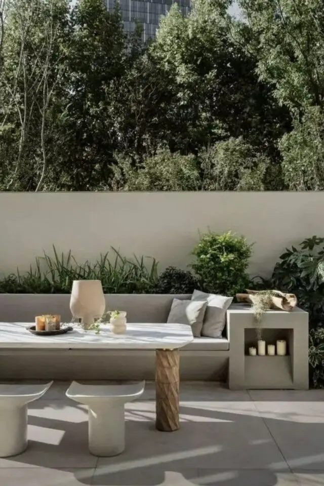 terrasse moderne en béton exemple maison de ville grande banquette table élégante tabouret design jardinière de plantes vertes 