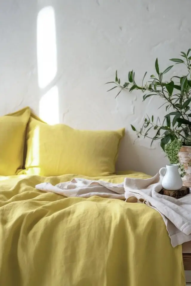 décoration chambre adulte couleur jaune exemple parure de lit colorée mur blanc enduit pas lisse plante verte 