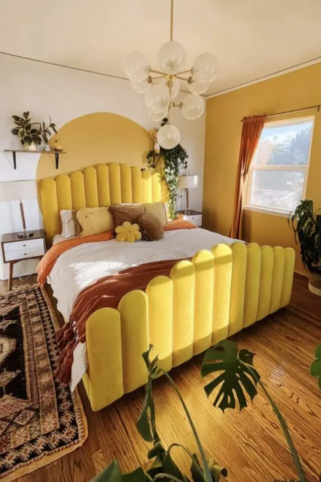 décoration chambre adulte couleur jaune exemple lit en velours tête de lit capitonnée arche peinture parquet plantes vertes 