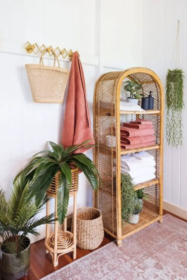 décoration salle de bain moderne touche bohème meuble en rotin tapis et draps de bain rose touche de couleur plantes vertes 