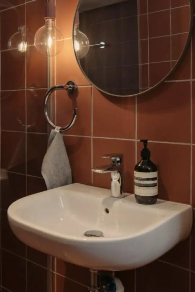 appartement meuble mid century moderne exemple salle de bain  lavabo blanc carrelage terracotta miroir rond 