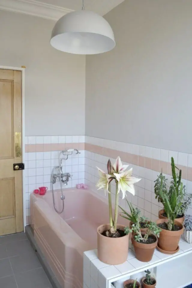 associer plantes vertes et déco rose salle de bain baignoire coloré et petites plantes en pot carrelage mural blanc avec frise colorée 