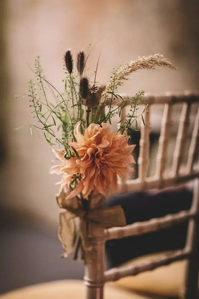 décoration mariage automne exemple fleur et feuillage maintenu avec un ruban pour décorer une chaise d'église 