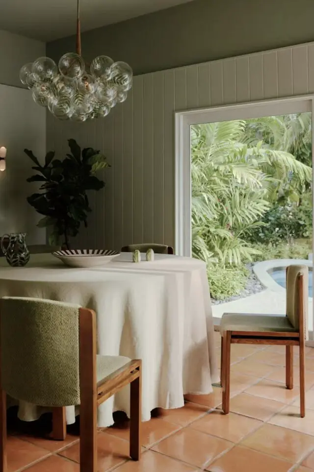 maison de vacances luxe Floride salle à manger table ronde chaise vintage bois et tissus vert mur lambris peint 