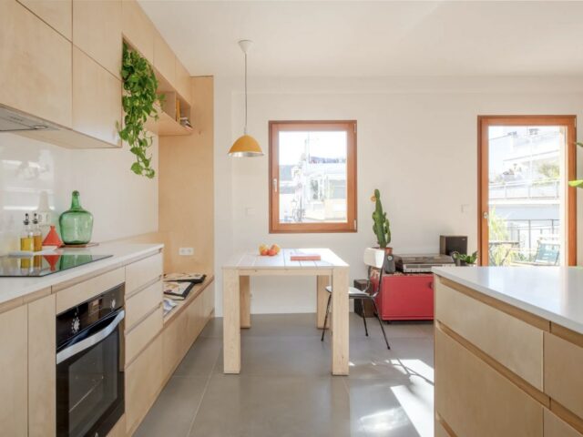 appartement 55m2 fonctionnel petite cuisine ouverte avec îlot et coin salle à manger composé d'une banquette table en bois et chaise 