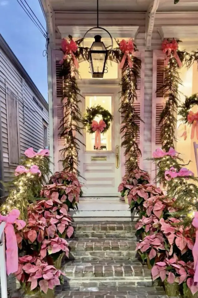 décoration extérieure noël exemple allée noeud et fleurs roses guirlande lumineuse couronne accrochée à la porte 