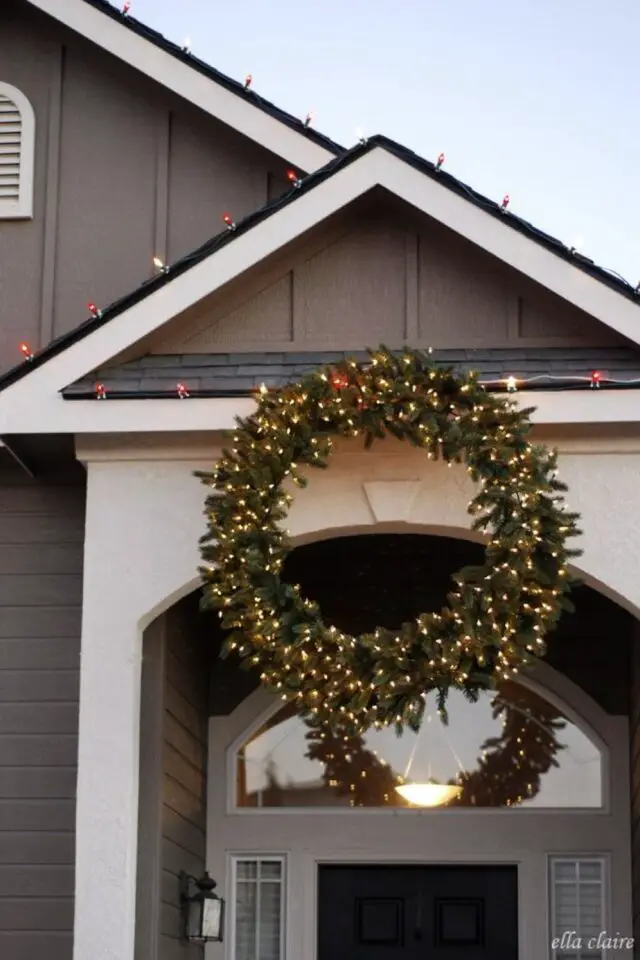 décoration extérieure noël exemple grande couronne de sapin avec des guirlandes lumineuses suspendues