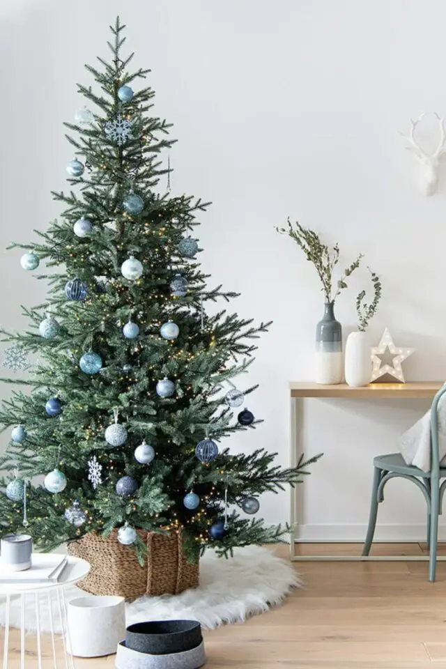 décoration de noël couleur bleu petit sapin boule bleue claire tapis en fausse fourrure cache-pot en osier 