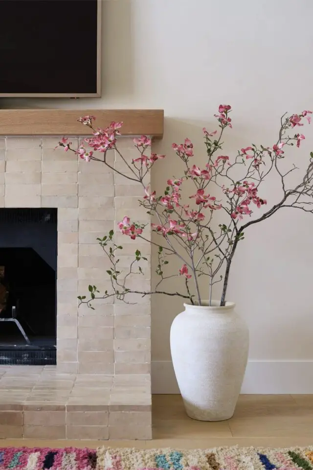 intérieur lumineux élégant et moderne détail décoration salon cheminée vase en céramique fleurs roses 