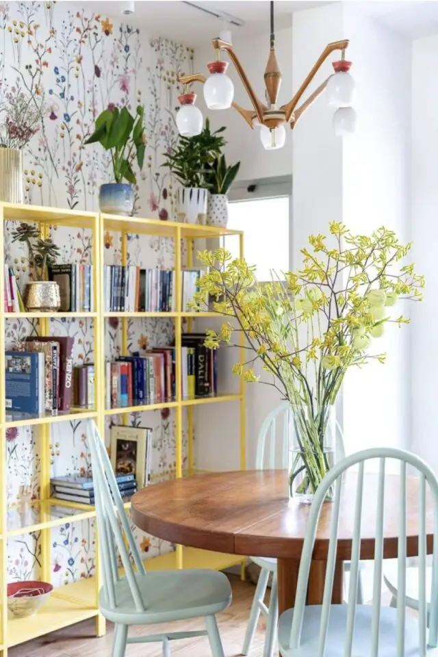 décor scandinave touche couleur salle à manger papier peint floral fond blanc bibliothèque métal jaune chaise en bois bleu pastel 