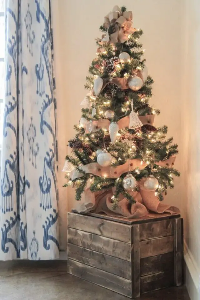 petit sapin de noël exemple décoration angle d'une pièce sur-élevé sur une caisse en bois décoration rose et blanc 