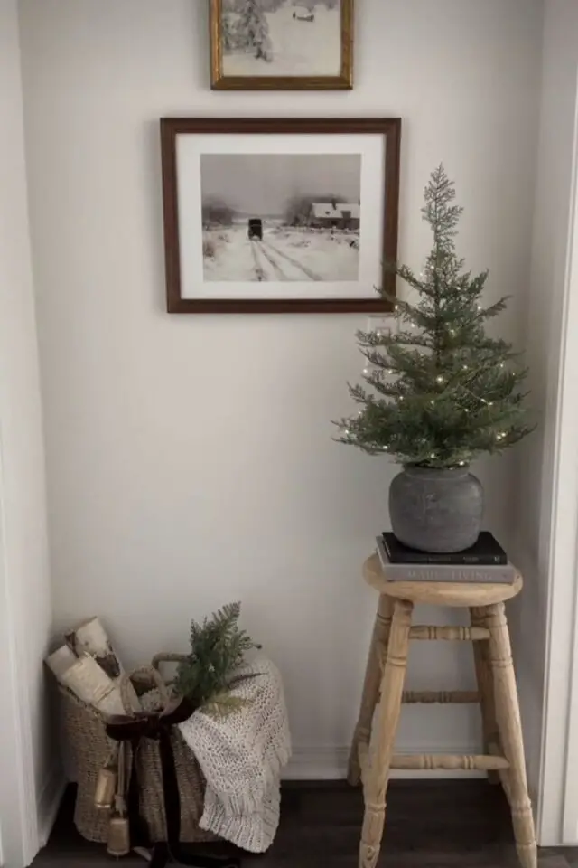 petit sapin de noël exemple décoration posé sur un tabouret angle d'une pièce pot de fleur arbre miniature 