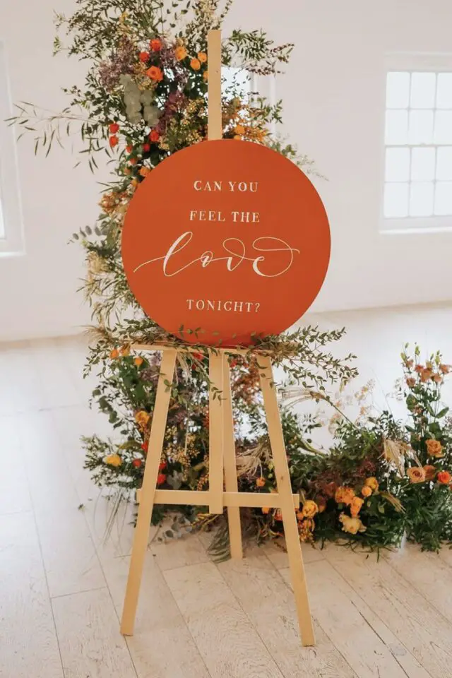 décoration mariage couleur orange idées entrée salle de réception panneau rond composition florale jolies typographies modernes 