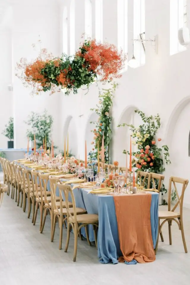 décoration mariage couleur orange grande table de réception nappe bleu chemin de table orange bougie chandelle colorée chaise en bois 