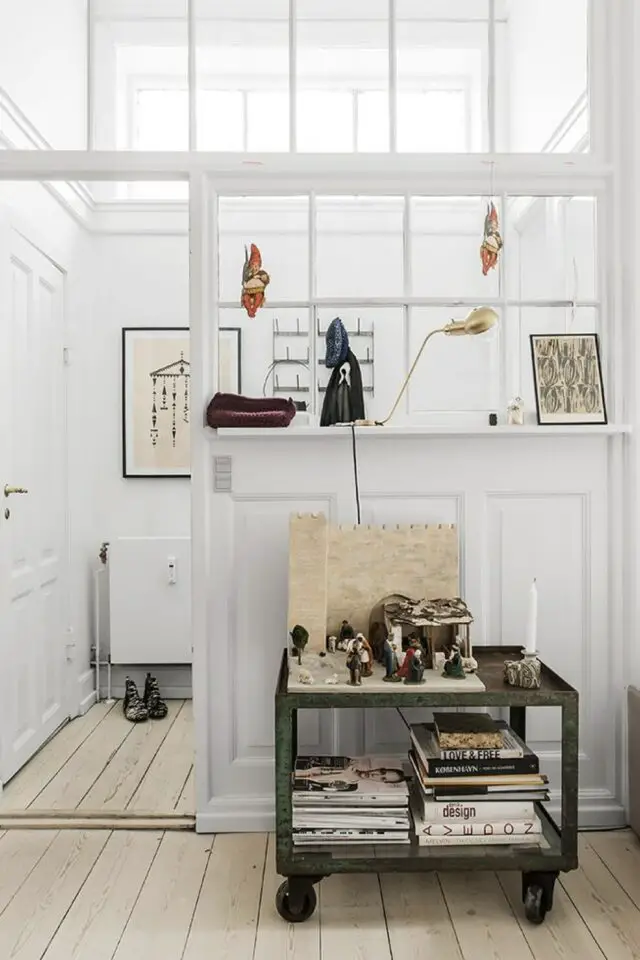 mix style kinfolk et vintage verrière élégante second jour blanche petit meuble d'appoint industriel en métal patiné sur roulette rangement livre et jeu d'échec 