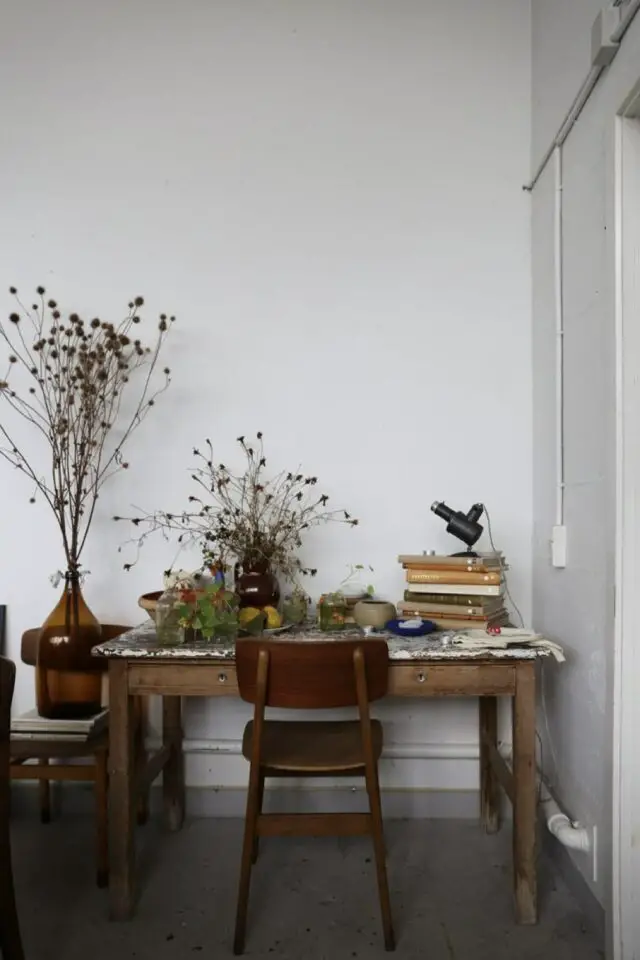mélange style kinfolk et vintage bureau table ancienne en bois chaise nappe fleurie pile de livre fleur vases dame Jeanne 